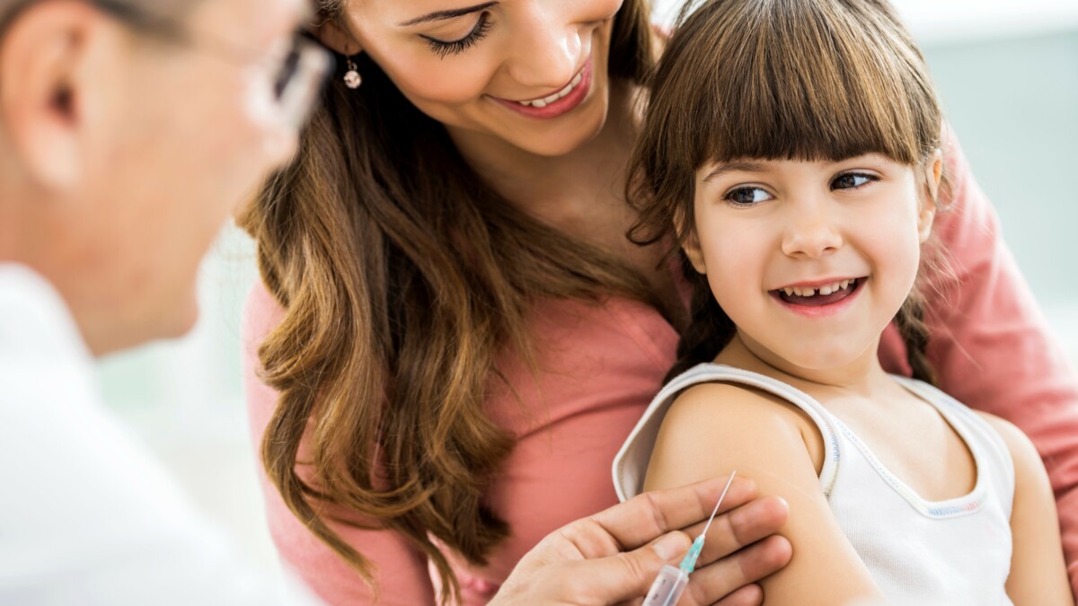 Mother and daughter at the doctor's. Little girl is receiving a vaccine.